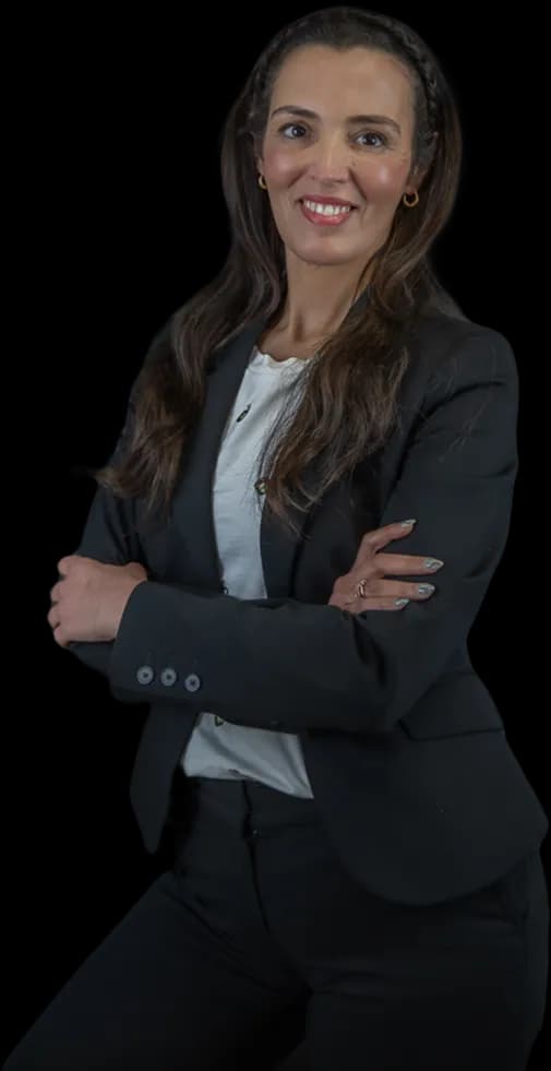 Persoon in nette werkkleding lacht vriendelijk naar je toe met de armen over elkaar heen.